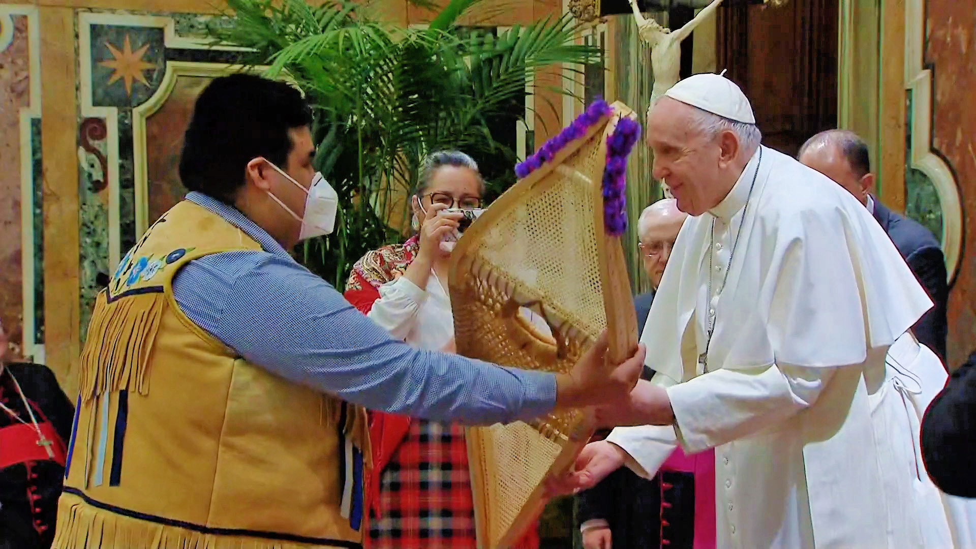 Pope Francis receiving a gift from a member of the Indigenous Delegation to Rome in March/April 2022