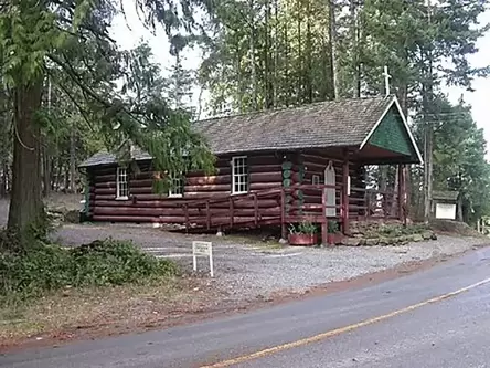 A small log cabin building in the woods