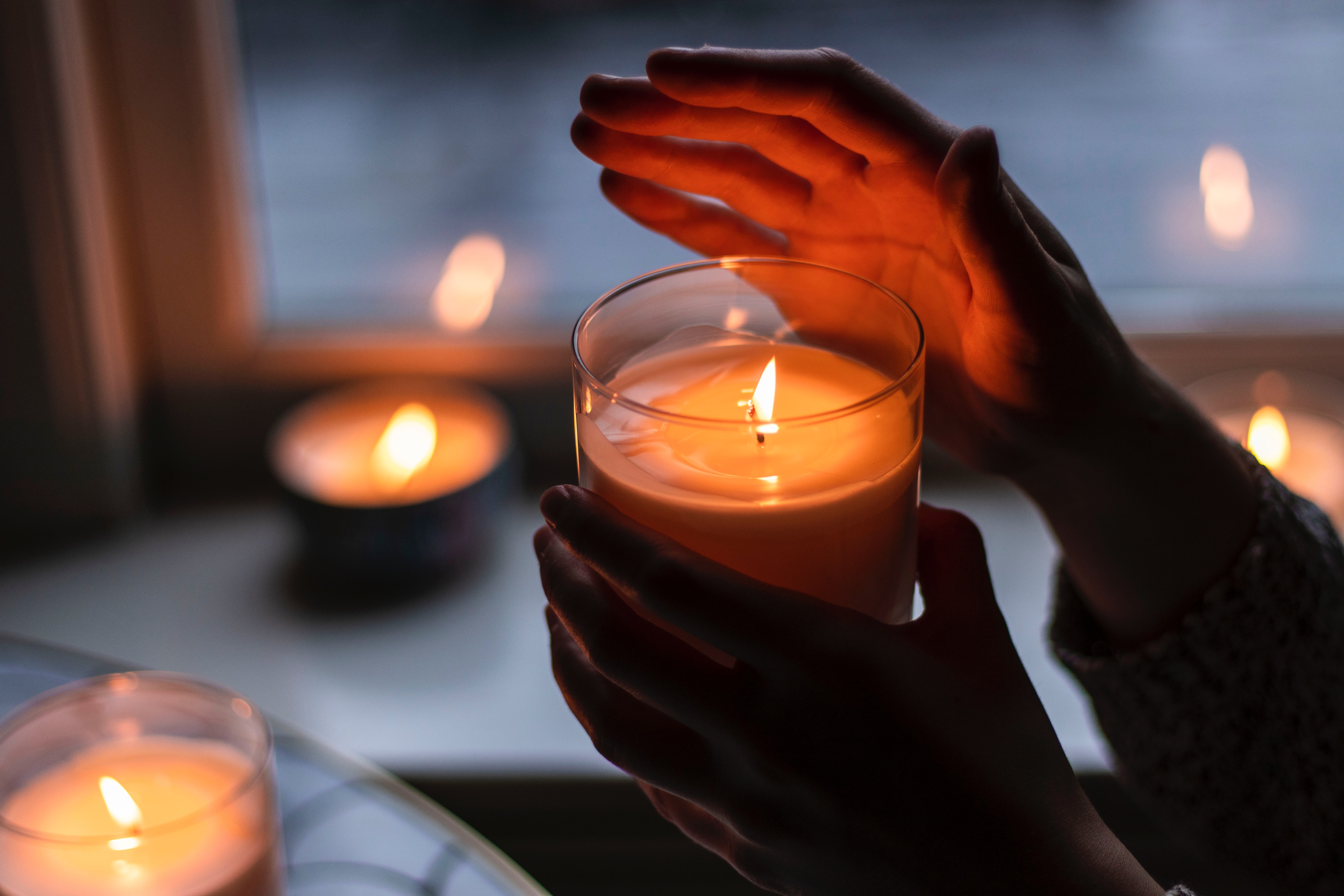 Hands holding a lit candle